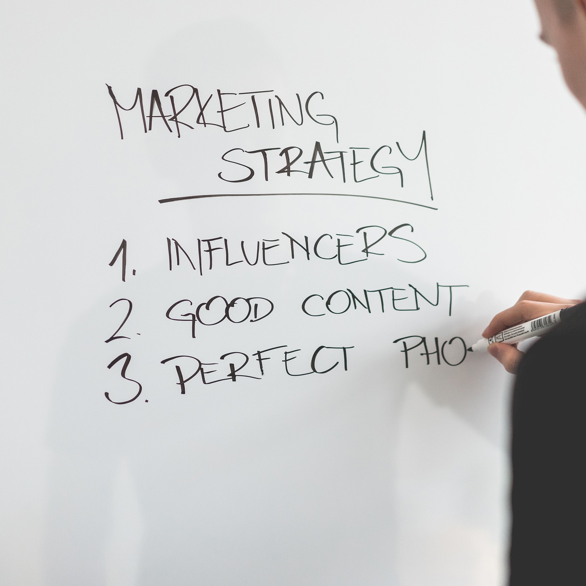 marketing-expert-writing-new-marketing-strategy-on-whiteboard-picjumbo-com-min